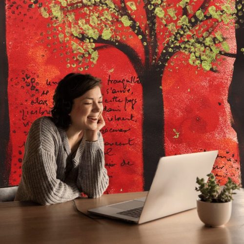 Femme souriant devant ordinateur arrière-plan artistique rouge